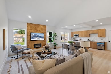 Living area with light wood-style floors, a stone fireplace, and recessed lighting