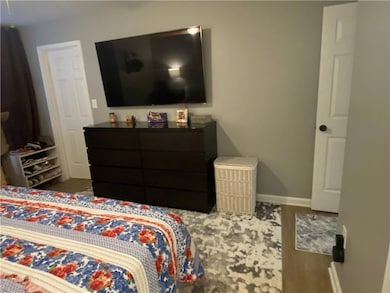 Bedroom featuring baseboards and wood finished floors