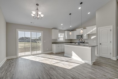 Kitchen featuring white cabinetry, light hardwood 