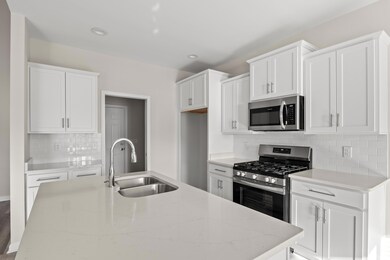 Kitchen featuring light stone countertops, white c