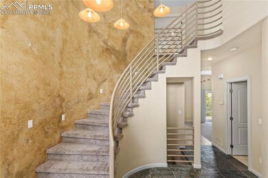 Stairway with a towering ceiling and dark tile flo