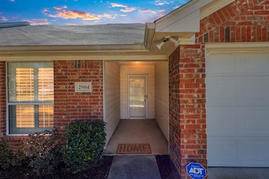 Exterior entry at dusk with an attached garage, a 