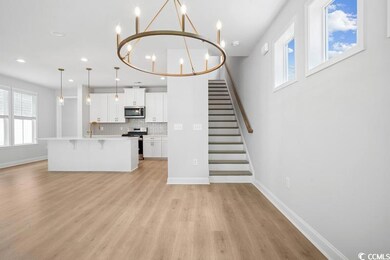 Unfurnished living room with a chandelier, light wood-style floors, stairs, and recessed lighting
