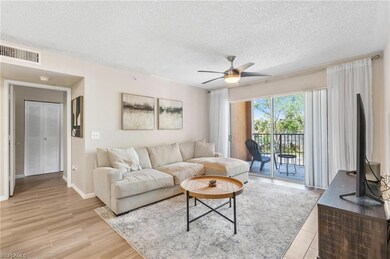Living room with a ceiling fan, a textured ceiling, light wood finished floors, and baseboards