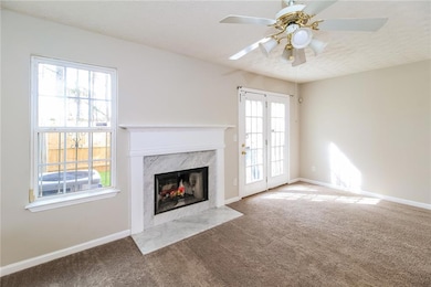 Unfurnished living room featuring carpet floors, a textured ceiling, and a fireplace