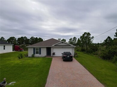 Ranch-style house with a garage and a front lawn