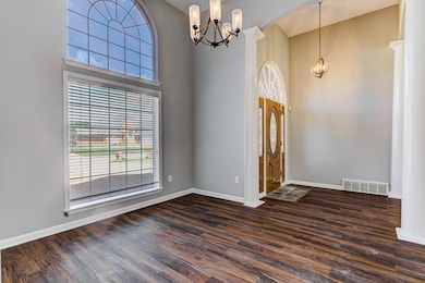 Unfurnished room featuring a chandelier, a high ce