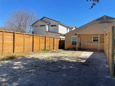 Back of house featuring fence and brick siding