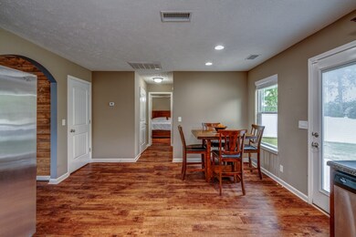 Dining space overlooks backyard through large window.
