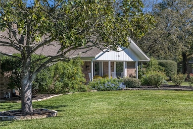 View of front of home featuring a front lawn, brick siding, and a porch