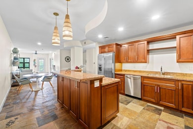 Kitchen with stone tile floors, a sink, appliance
