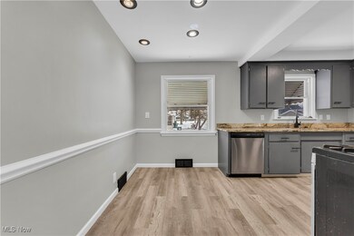 Kitchen featuring dishwasher, stove, sink, and gray cabinetry