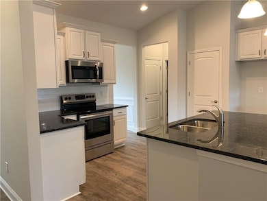 Kitchen featuring wood finished floors, white cabi