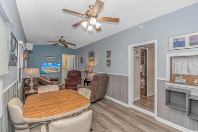 Dining area with ceiling fan, wooden walls, lofted