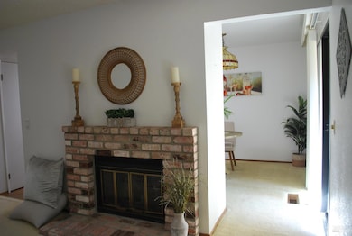 A Wood Burning Brick Fireplace in the Living Room - Entry into the Dining Area