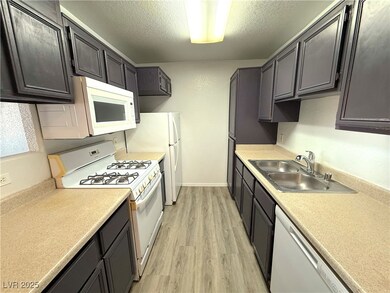 Kitchen with white appliances, light wood finished