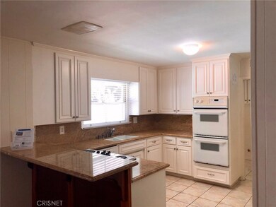 Upgraded kitchen, newer cabinets, counters and desk, with adjacent laundry room