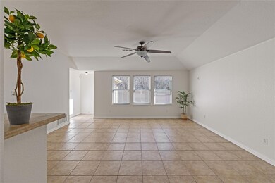 Tiled empty room with ceiling fan and vaulted ceil