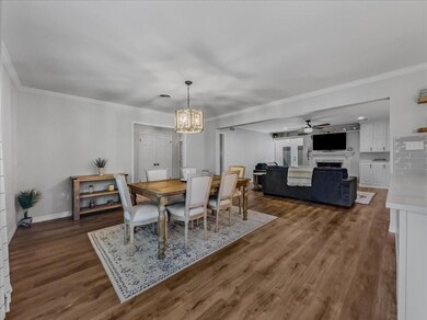 Dining area featuring LVP floors, ornamental molding, and notable chandelier