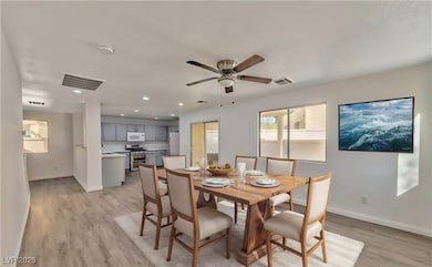 Dining area with baseboards, visible vents, and li