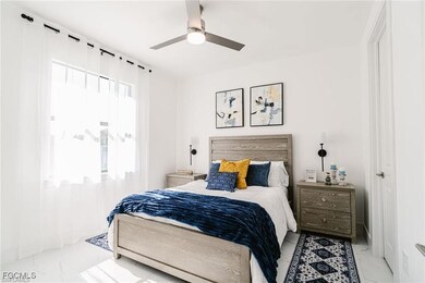 Bedroom featuring a ceiling fan and marble look tile flooring