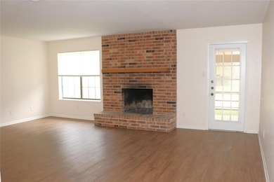 Unfurnished living room featuring baseboards, woo