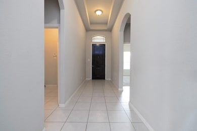 Hallway featuring light tile patterned floors and