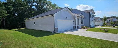 View of side of home featuring a garage and a lawn
