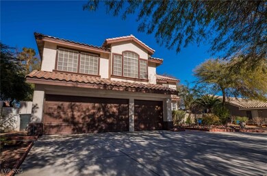 Mediterranean / spanish house with stucco siding, driveway, an attached garage, and a tiled roof