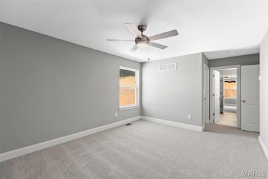 Carpeted empty room featuring ceiling fan