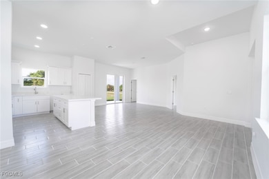 Kitchen featuring white cabinets, recessed lighting, a center island, plenty of natural light, and open floor plan