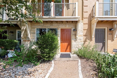 Property entrance with a balcony, stone siding, a