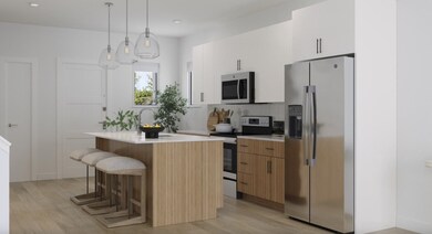 Kitchen with appliances with stainless steel finishes, a breakfast bar area, pendant lighting, tasteful backsplash, and white cabinets