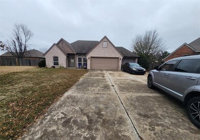 View of front of property with a garage and a front lawn