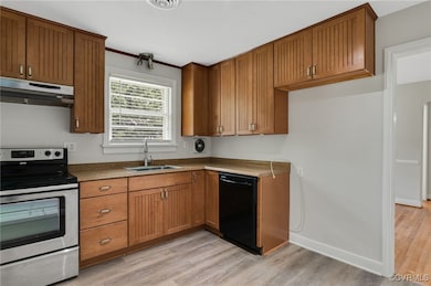 Kitchen with LVP floors, a sink, stainless steel e