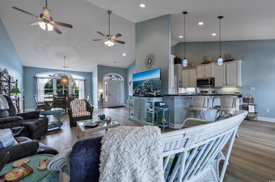Living room with ceiling fan, high vaulted ceiling