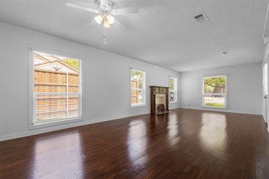 Unfurnished living room featuring dark wood finished floors and ceiling fan