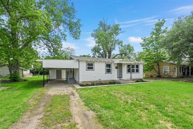 View of front of property with a carport and a front yard