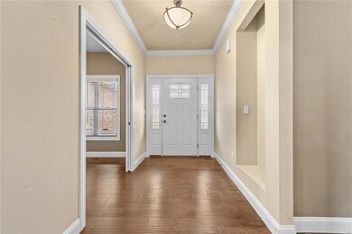 Foyer entrance with dark wood-type flooring and ornamental molding