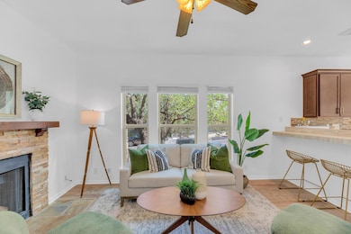 Living area with a fireplace, ceiling fan, recess