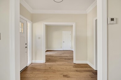 Corridor with ornamental molding and light hardwoo