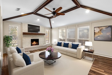 Living area featuring dark wood-style flooring, a ceiling fan, a brick fireplace, and recessed lighting