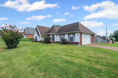 View of front of property featuring brick siding, an attached garage, driveway, and a shingled roof