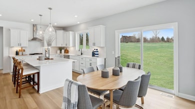 (Photo of a decorated model, actual homes finishes will vary) Soaked in natural sunlight, the homes eat-in dining room has ample space for a dining table located in the heart of the home.