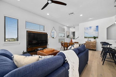 Living room with recessed lighting, light wood-type flooring, and a ceiling fan