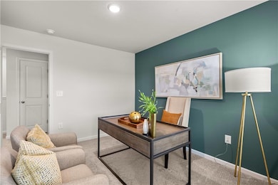 Carpeted office space with baseboards