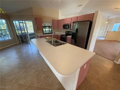 Kitchen featuring vaulted ceiling, light tile patt