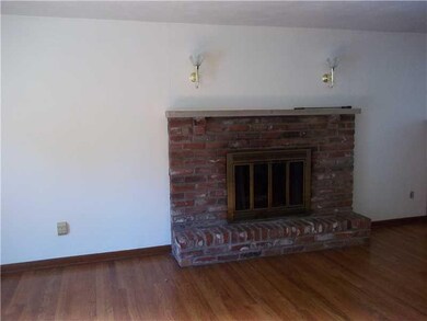 Living Room. hardwood floors with brick fireplace.