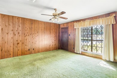 Carpeted spare room featuring ceiling fan and wood