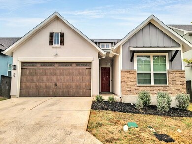 View of front of house with a garage, driveway, board and batten siding, and stucco siding